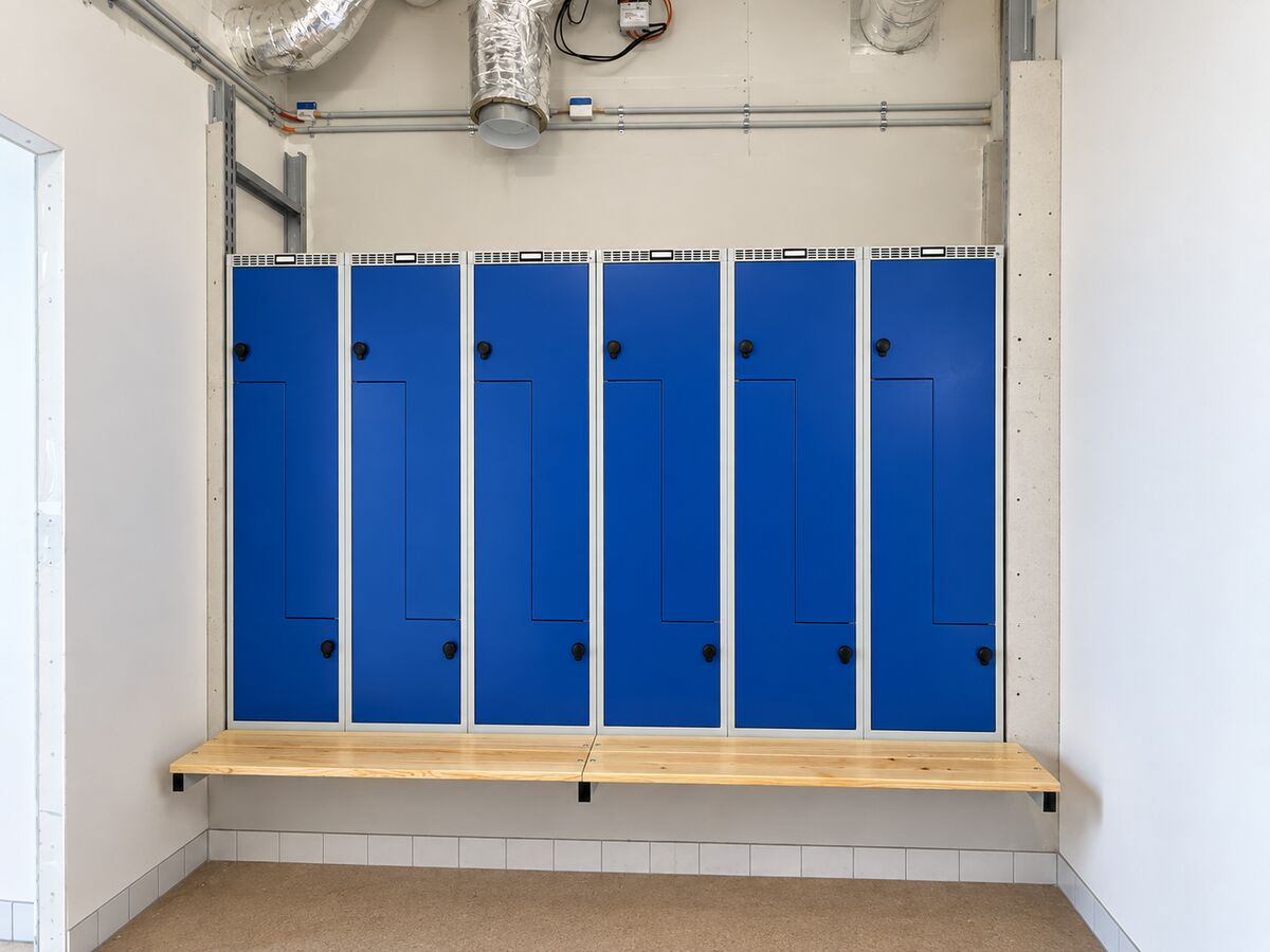 Blå omklædningsskabe med svævende træbænk monteret i Køge